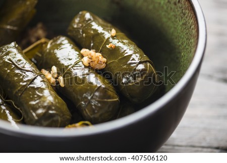 Stuffed vine leaves, or dolmades, in a bowl. Close up. Stuffed Mediterranean vine leaves. International cuisine. Royalty-Free Stock Photo #407506120
