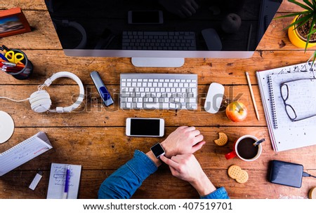 Business person working at office desk wearing smart watch
