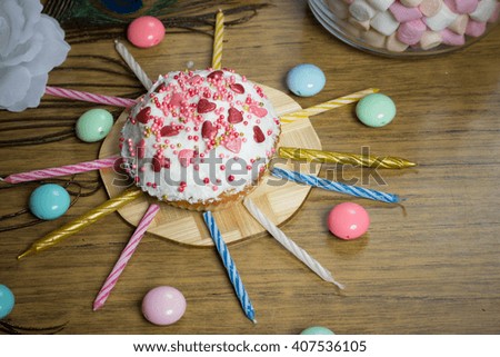 Celebrating sweet cupcake, candles on wooden table, candies, birthday party preparation, celebration food photo