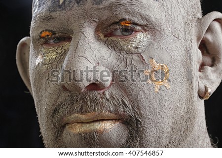 close-up portrait of a man in the clay body art , studio on a dark background