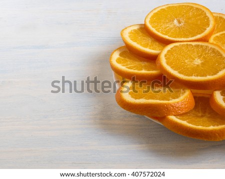 sliced oranges on a plate. Wooden background