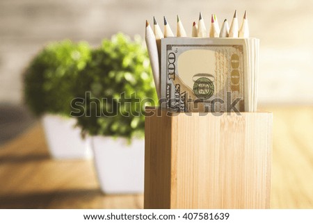 Wooden desktop with plants and pencil holder with dollars
