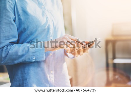 Photo business woman wearing jeans shirt, touching smartphone screen. Modern loft office. Blurred background. Horizontal mockup. Film effect