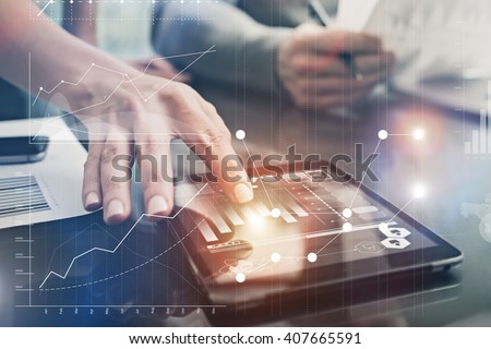 Closeup photo female hands touching screen modern tablet. Account managers working new investment project in office. Using electronic devices. Graphics icons, worldwide stock exchanges interface. 