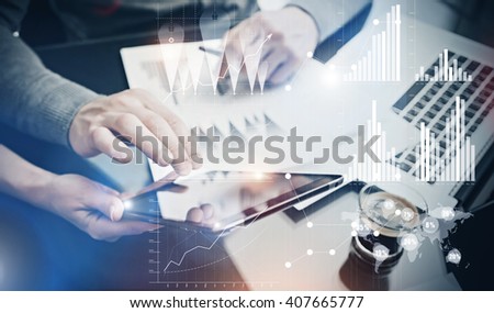 Photo teamwork process. Risk department managers working new global project in office. Using electronic devices. Graphics icons, worldwide stock exchanges interface. Horizontal
