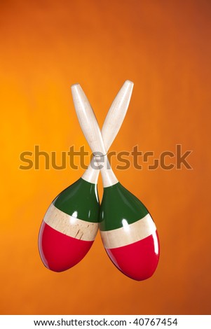 A set of Latin African maracas isolated against a yellow gold background in the vertical format.