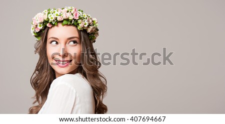 Portrait of a gorgeous brunette woman wearing spring flower wreath.