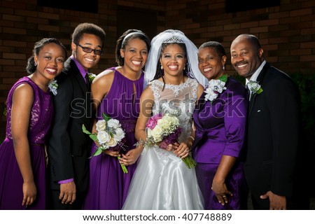 A beautiful African American bride poses for a picture with her family before her wedding.