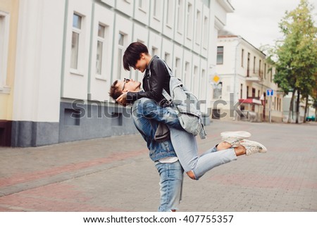 young couple of hipsters in a leather jacket jeans t-shirt, posing on the street, romantic kiss at sunset, a tender embrace, wedding, girlfriend and boyfriend, lovers outdoor portrait,together forever Royalty-Free Stock Photo #407755357