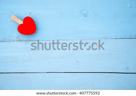 Red heart hung on the rope a wooden background