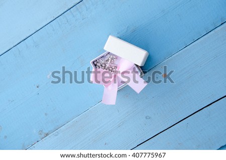 Gift box with bow over white wooden table with copy space