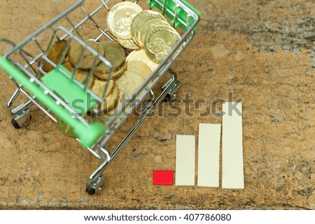 Trolley filled with coins beside chart showing increasing / rising trend. Concept of growth in business,spending and purchasing power,economy. Concept of inflation. Concept of financial issue.