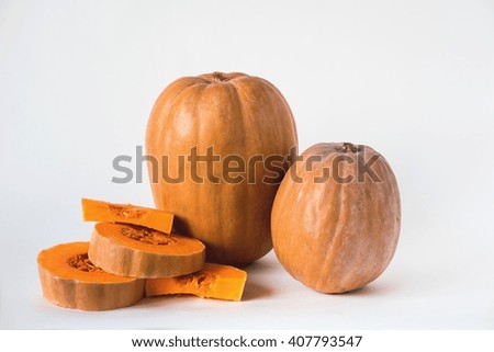 Two whole pumpkin and sliced on a white background, vegetarian food, organic, orange, health