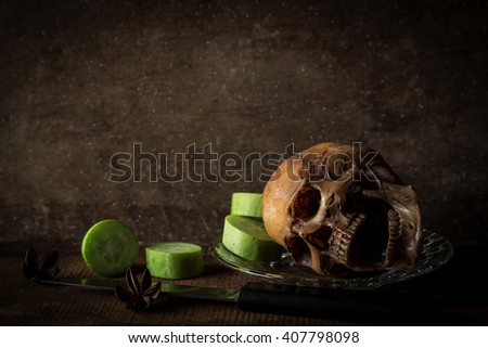 Still life photography with skull and slice cucumber 