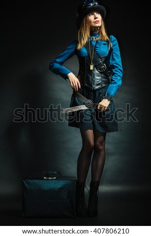 Journey and travel. Retro stylished girl with vintage big bag suitcase valise. Stylish victorian woman on dark background.