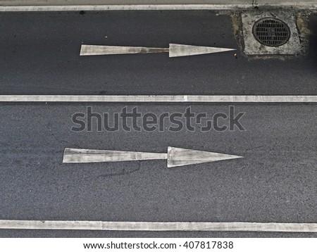 One-way signs and double middle lines on a road/One Way Road with cover the drain. One direction allow.