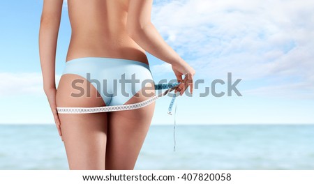 hand with meter,buttocks and legs of slim woman isolated on sea summer background