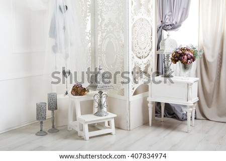 Shabby chic interior. Wedding decor, room decorated for rustic wedding, with bedside table, folding screen or room divider with white tracery and rose bouquets. High key Royalty-Free Stock Photo #407834974