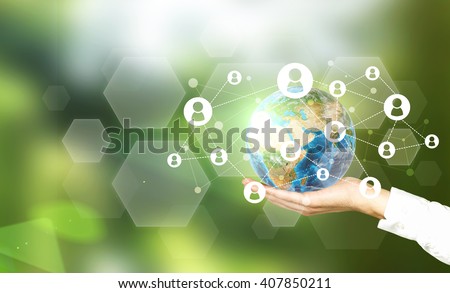Terrestrial globe with networking system in male palm on abstract green background. Elements of this image furnished by NASA