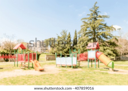 Defocused background of colorful playground for kids in public park. Intentionally blurred post production for bokeh effect