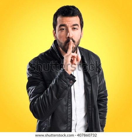 Man with leather jacket making silence gesture