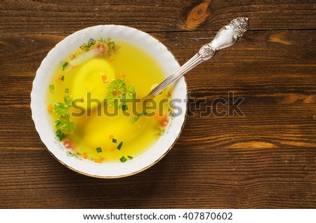 broth with vegetables in plate on wooden table .Rustic style.Top view. Free space for text.