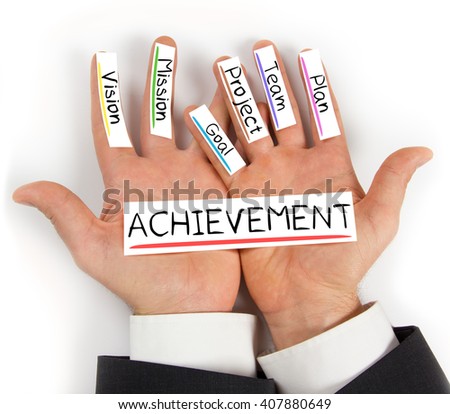 Photo of hands holding ACHIEVEMENT paper cards with concept words