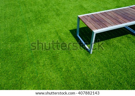 Wooden bench on the green grass with copy space