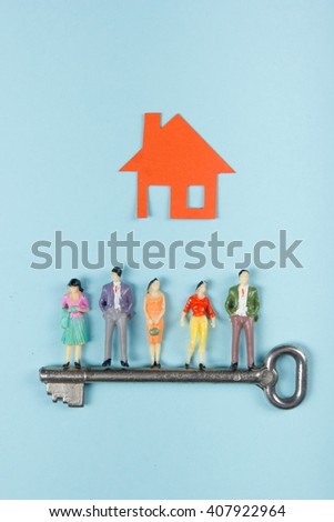 Real Estate concept. Model house, construction, house building. Paper house and people figures with key on blue background. Top view. Copy space for text