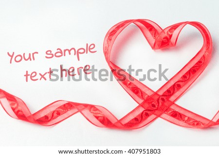 Red tape in the form of heart with swirls . On a white textured background. With copy space. Shallow DOF