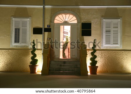 Entrance to old mediterranean style house at night with lights