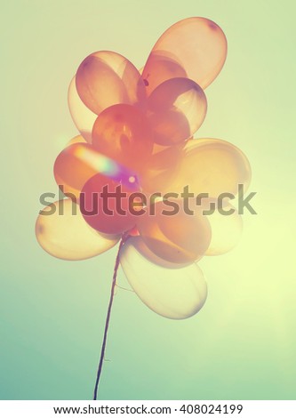Vintage photo of colorful balloons on blue sky. Concept of love in summer, valentine, wedding and honeymoon