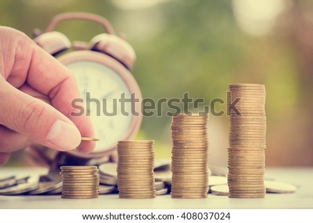 Close up of hand stacking coins with green bokeh background ,Business Finance and Money concept,Save money for prepare in the future.