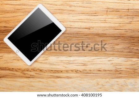 Digital tablet computer with isolated screen with clipping path on wooden background.