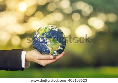 Businesswoman hand holding earth with blurred nature background. Ecology concept. World Environment Day concept, Earth day, Elements of this image are furnished by NASA