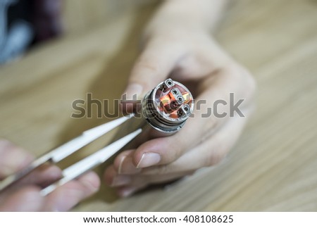 The man pulls the coil for electronic cigarettes