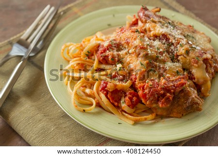Hot and crispy chicken parmesan in savory red tomato sauce Royalty-Free Stock Photo #408124450