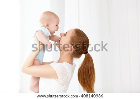 happy family mother playing  with newborn baby