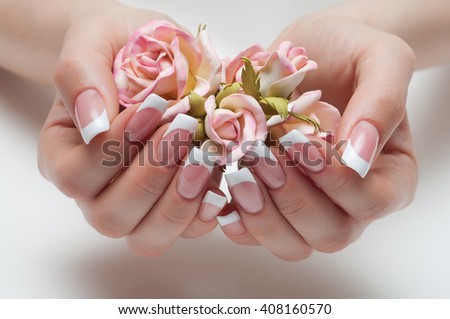 delicate French manicure with a rose in hand Royalty-Free Stock Photo #408160570