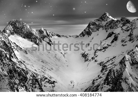 Snowy mountains in the moonlight and the stars. Night winter mountain landscape.