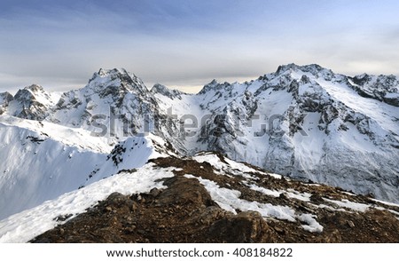 Beautiful high snowy mountains in winter at sunset. Winter mountain landscape.