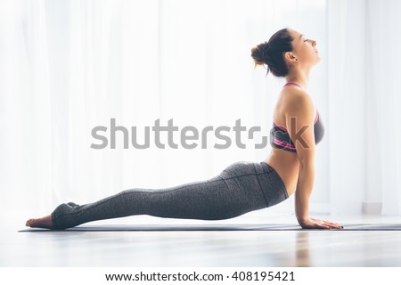 Urdhva mukha svanasana. Beautiful yoga woman practice in a training hall background. Yoga concept. Royalty-Free Stock Photo #408195421