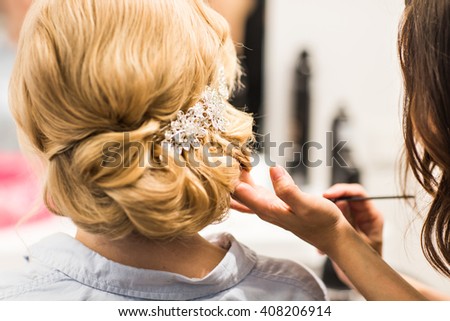 Hair stylist makes the bride before a wedding Royalty-Free Stock Photo #408206914
