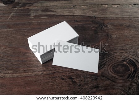 Photo of blank business cards on dark vintage wooden background. For design presentations and portfolios.