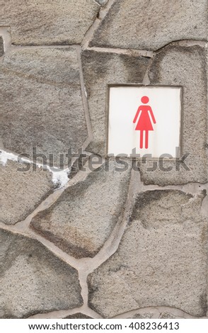 the sign of restroom for lady on stone wall background 