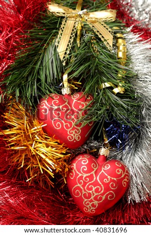 christmas hearts hanging on fir branch on tinsel background