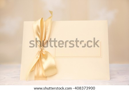 Blank Card with bow is on the table on the blurred background, for invitation, congratulation