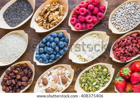 Super food, fruits, berries, nuts, seeds top view on rustic wood background. Detox, superfood concept. Royalty-Free Stock Photo #408375406