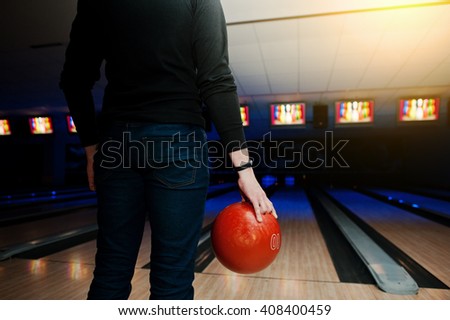 Hand of man player with bracelet holding bowling ball