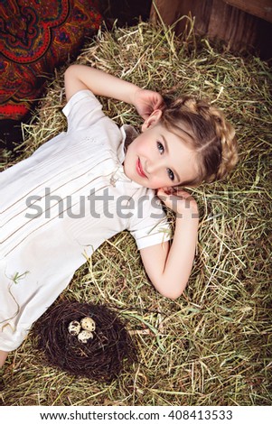 Portrait of girl in white dress on the haystack